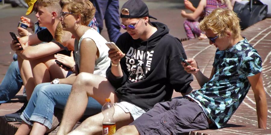 Noch können sie es geniessen: Französische Schüler mit ihrem Smartphone auf dem Schul-Areal. Bald wird das Handy-Verbot in Kraft treten.