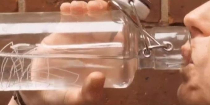 Ein Mann trinkt Wasser aus einer Glasflasche. Ein Mann trinkt Wasser aus einer Glasflasche.