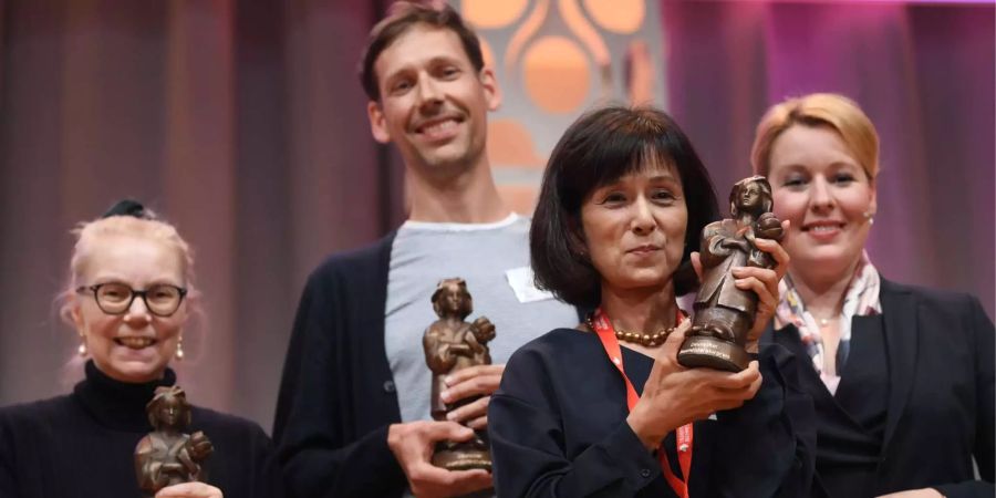 Die Übersetzerin Ursula Gräfe (l-r), der Illustrator Jörg Mühle und die Autor derin Megumi Iwasa aus Japan halten die Momo-Trophäe für das beste Kinderbuch.