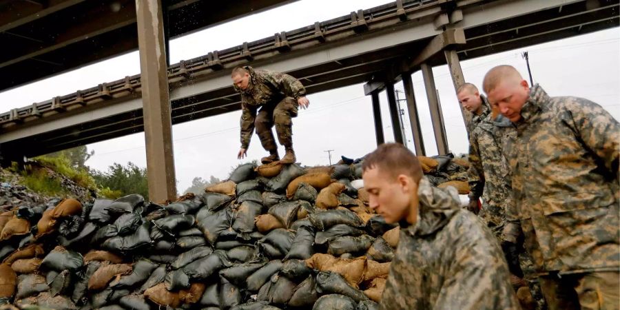 Mitglieder der North Carolina Nationalgarde stapeln Sandsäcke unter einer Autobahnüberführung in der Nähe des Lumber River, der voraussichtlich über die Ufern treten soll.