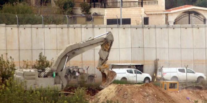 Ein Bagger arbeitet vor einer Mauer in Israel.