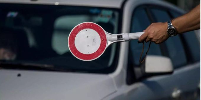 Ein Grenzpolizist hält ein Auto an der Grenze. Seit den strengen Kontrollen dauert die Anfahrt für Grenzgänger und Grenzgängerinnen mehrere Stunden. Coronavirus