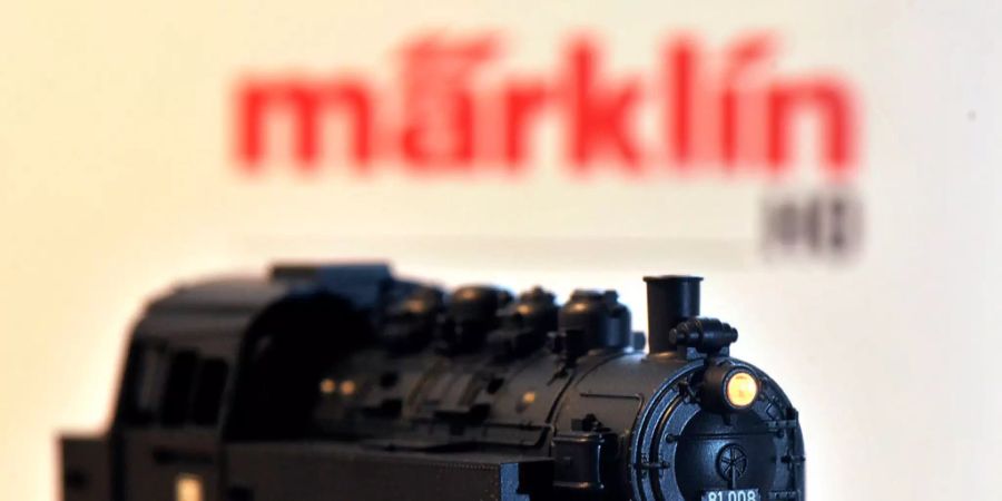 Eine Modelleisenbahn der Firma Märklin mit dem verschwommenen Logo im Hintergrund.