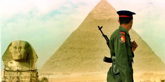 Ein bewaffneter Soldat steht neben der Cheopspyramide und der Sphinx nahe Gizeh (EGY) Wachen.