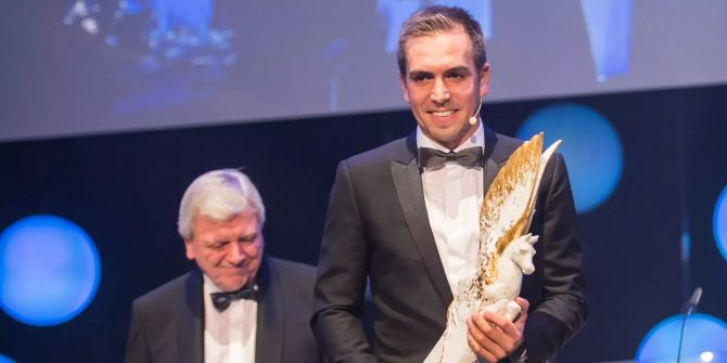 Philipp Lahm, Fussball-Weltmeister, hält die Pegasus-Trophäe «Legende des Sports» in seinen Händen.