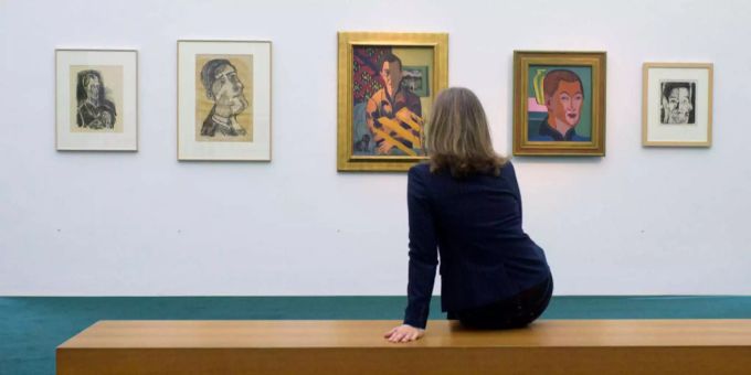 Eine Frau sitzt vor mehreren Gemälden im Kirchner Museum in Davos GR. Eine Frau sitzt vor mehreren Gemälden im Kirchner Museum in Davos GR.