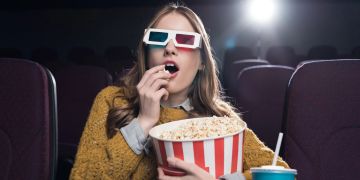 Frau im Kino mit Popcorn