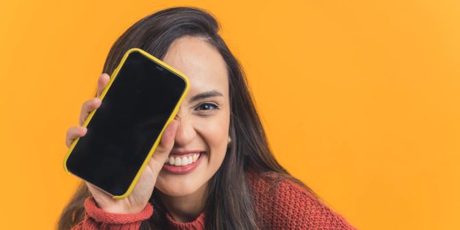 frau mit braunen haaren und smartphone in der hand