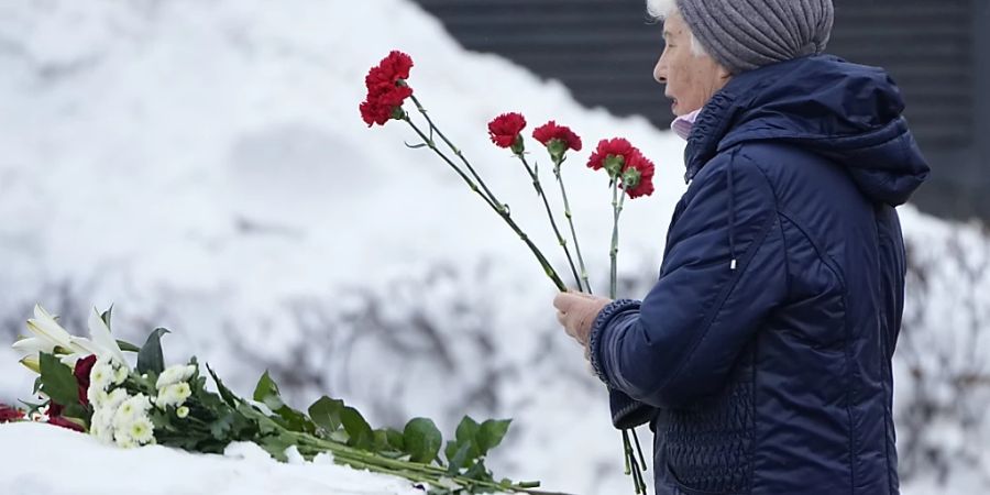 Eine Frau legt Blumen nieder, um Nawalny die letzte Ehre zu erweisen. Foto: Alexander Zemlianichenko/AP/dpa