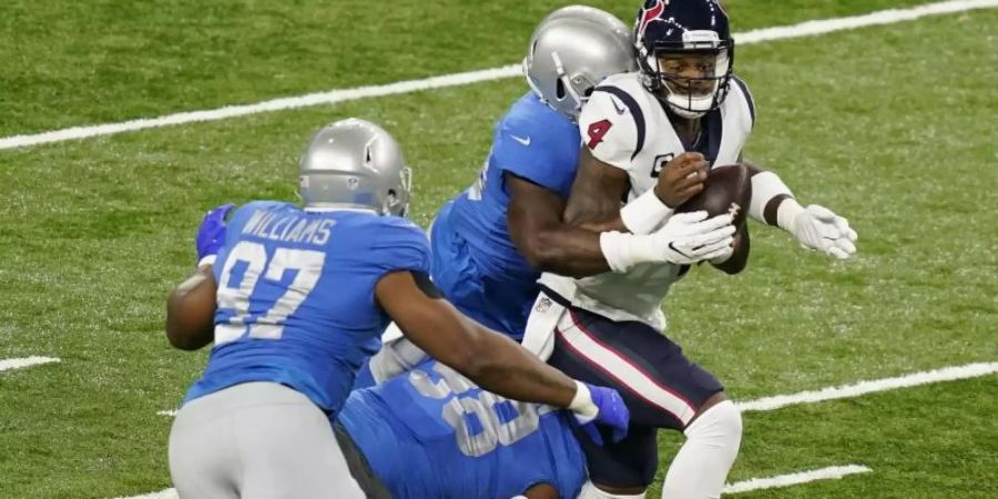 Deshaun Watson (r) von den Houston Texans wird mit einem Tackling von Spielern der Lions zu Fall gebracht. Foto: Carlos Osorio/AP/dpa