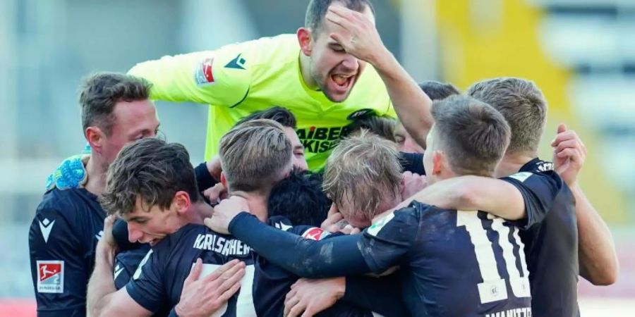 Karlsruhes Mannschaft jubelt über das Tor zum 3:2-Sieg beim SV Sandhausen. Foto: Uwe Anspach/dpa