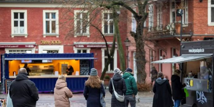 Menschen vor einem Verkaufsstand Menschen vor einem Verkaufsstand