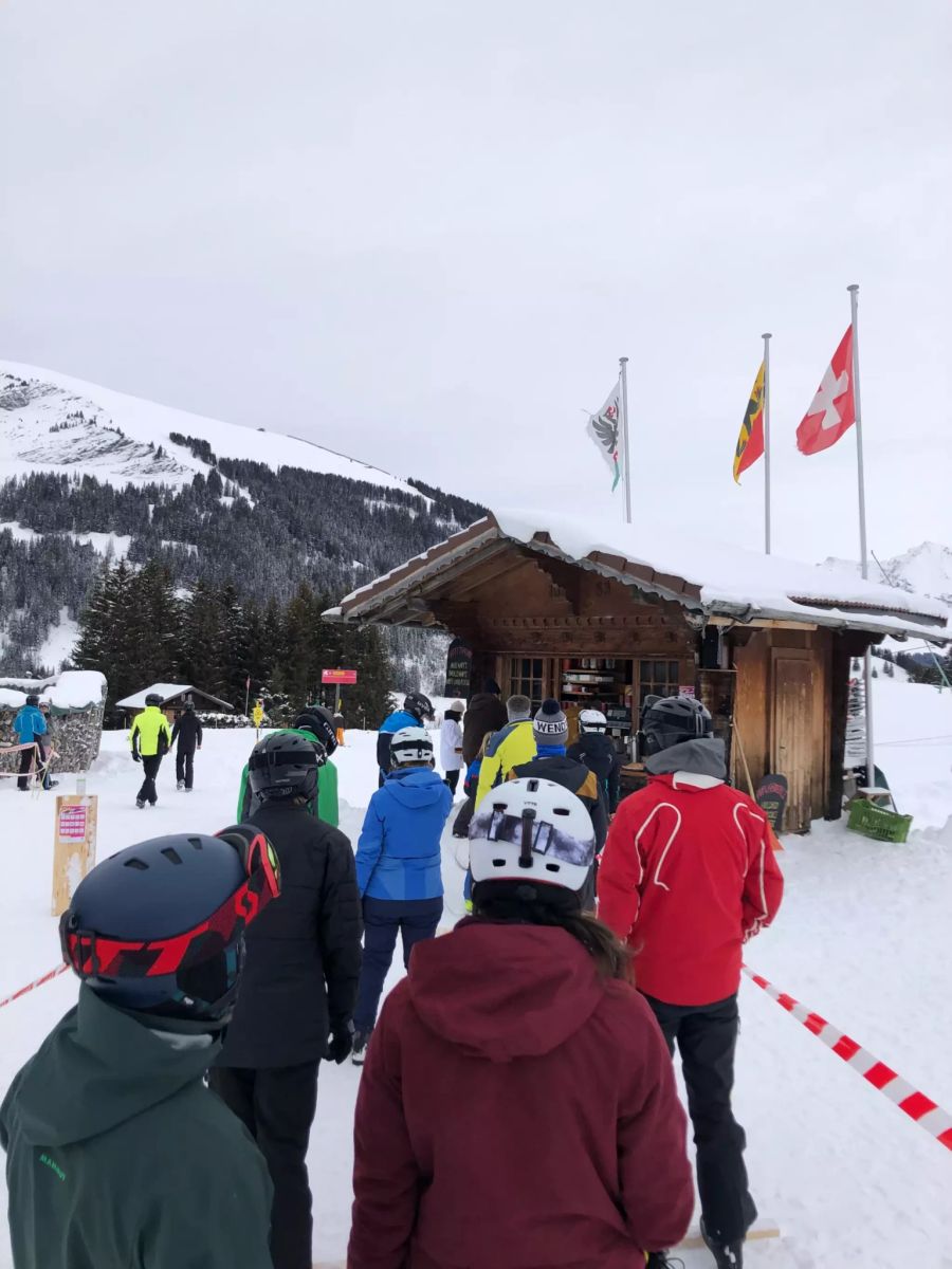 Wintersportler in Adelboden BE stehen für Take-away-Essen Schlange.