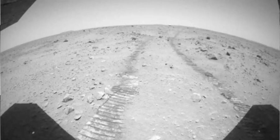 Ein von der China National Space Administration (CNSA) veröffentlichtes Foto zeigt Radspuren, die der Marsrover «Zhurong» hinterlassen hat. Foto: CNSA/XinHua/dpa