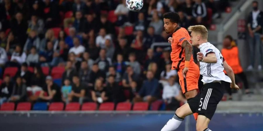 Amos Pieper (r) kämpft mit dem Niederländer Justin Kluivert um den Ball. Foto: Marton Monus/dpa