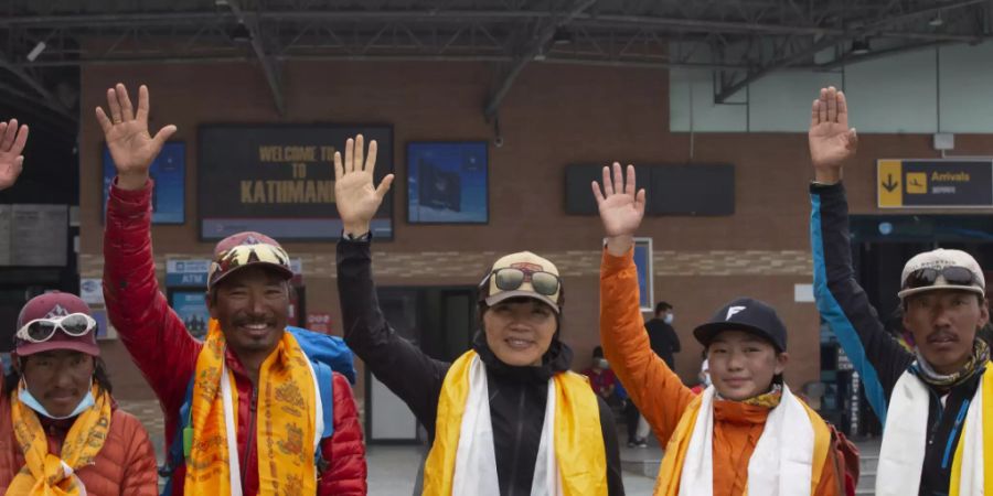 Tsang Yin-hung (M) aus Hongkong winkt während einer Pressekonferenz anlässlich ihres aufgestellten Rekordes für den Aufstieg des Mount Everest. Foto: Bikram Rai/AP/dpa