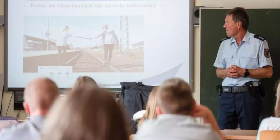 Bundespolizist Manfred Ludwig klärt Kinder der Klassen 5 und 8 über Gefahren im Bahnumfeld auf, unter anderem über die Gefahren von Fotos im Bahngleis. Foto: Nicolas Armer