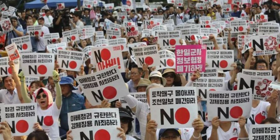 Demonstranten mit Schildern mit der Aufschrift «Wir verurteilen den japanischen Premierminister Shinzo Abe» protestieren vor der Botschaft Japans in Seoul gegen Handelsbeschränkungen. Foto: Ahn Young-Joon/AP