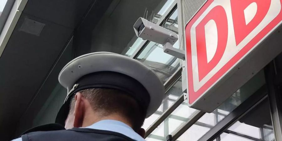 Ein Bundespolizist steht im Berliner Bahnhof Südkreuz unter einer Kamera für die Gesichtserkennung. Foto: Wolfgang Kumm