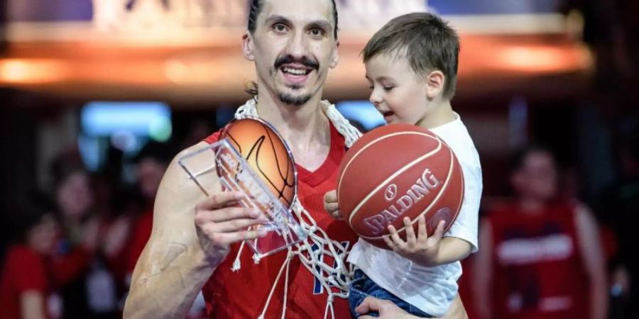Nihad Djedovic von München jubelt mit der Auszeichnung «Most Valuable Player» in der Hand und seinem Sohn auf dem Arm. Foto: Matthias Balk