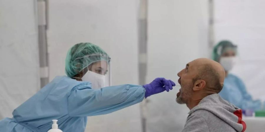 Eine Mitarbeiterin des spanischen Gesundheitswesens nimmt einen Abstrich. In Spanien wächst die Sorge einer zweiten Corona-Welle. Foto: Javi Colmenero/EUROPA PRESS/dpa