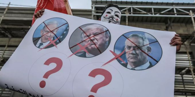 Ein palästinensischer Demonstrant hält während eines Protests gegen den israelischen Annexionsplan in einem Flüchtlingslager Bilder von dem israelischen Premierminister Netanjahu und dem US-Präsidenten Trump, die durchgestrichen sind. Demonstration israelische Annexionspläne