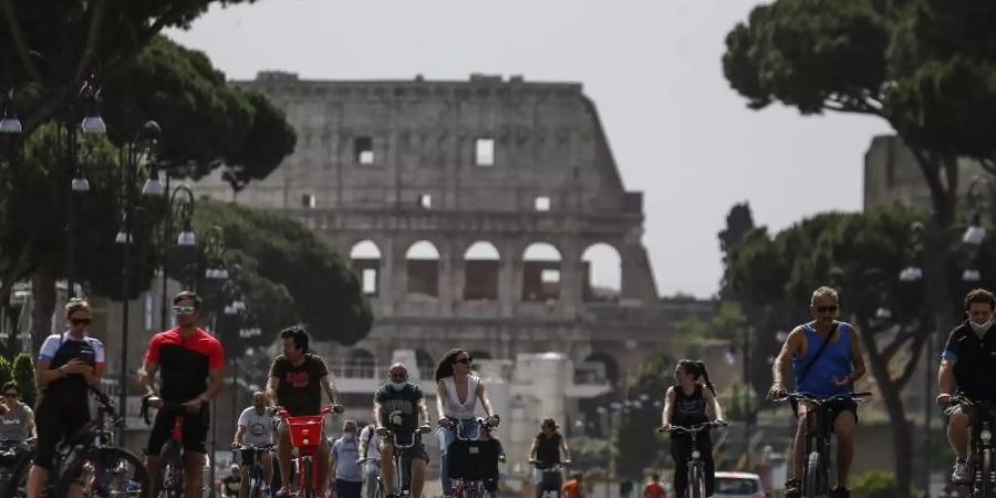 Radfahrer sind auf der Strasse vor dem Kolosseum unterwegs. Foto: Cecilia Fabiano/LaPresse/AP/dpa