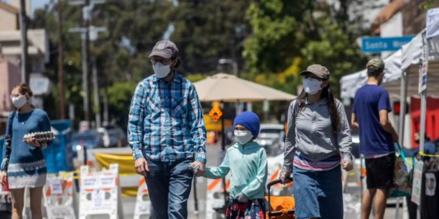 Familie mit Schutzmasken auf einem Markt in Santa Monica