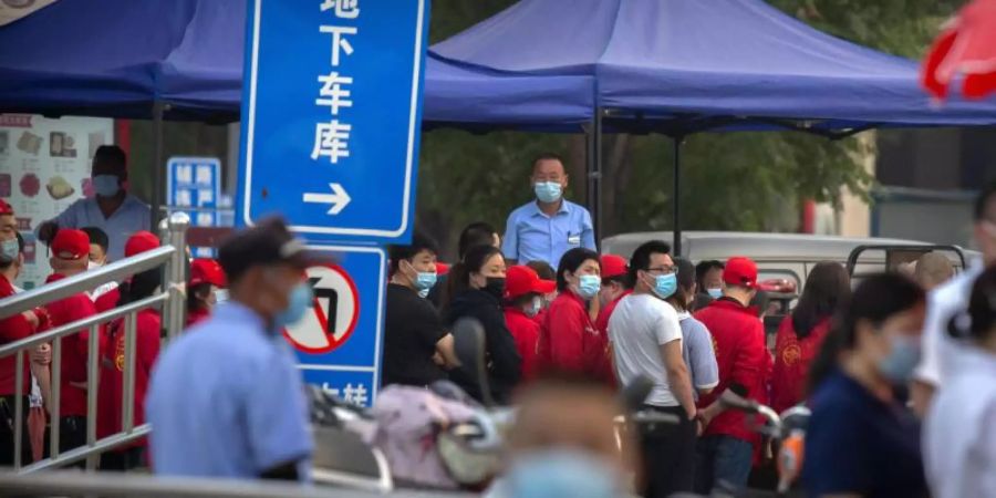 Polizisten sichern einen Fleischmarkt, der von den Behörden geschlossen wurde, nachdem bekannt wurde, dass ein Besucher des Marktes positiv auf das Coronavirus getestet worden war. Foto: Mark Schiefelbein/AP/dpa