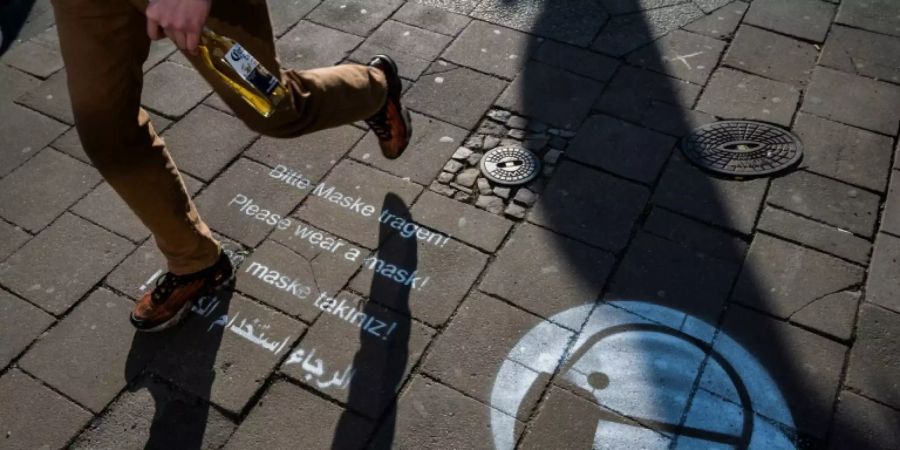 Hinweis zum Maske-Tragen auf einer Strasse in Berlin