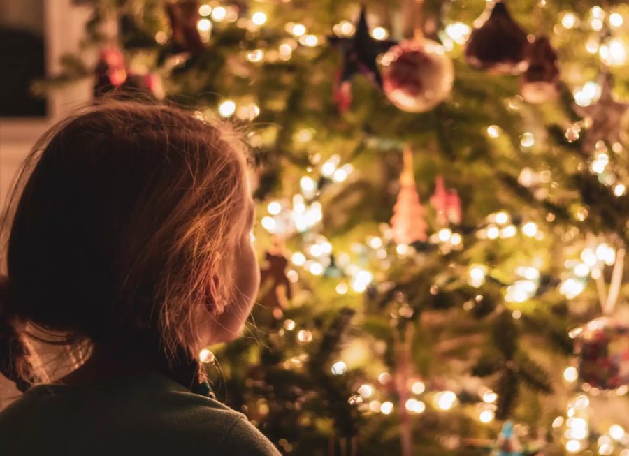 Mädchen vor Weihnachtsbaum.