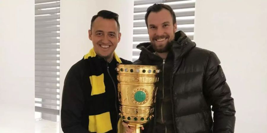 Gastronom Christopher Reinecke (l) und sein Geschäftspartner Kevin Grosskreutz mit dem Duplikat des DFB-Pokals. Foto: Christopher Reinecke/dpa