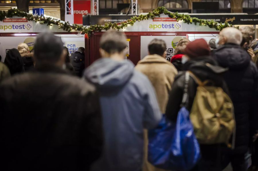 Personen stehen in der Warteschlange für einen Covid-19 Coronavirus Antigen-Schnelltest oder PCR-Speicheltest bei einem Testzentrum in der grossen Halle des Zürcher Hauptbahnhofs, am Freitag