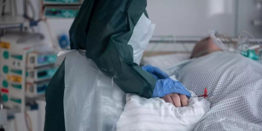 Eine Mitarbeiterin der Pflege betreut einen Covid-Patienten im nordrhein-westfälischen Essen. Die Gesamtzahl der nachgewiesenen Corona-Infektionen in Deutschland hat die Fünf-Millionen-Marke überschritten. Foto: Fabian Strauch/dpa