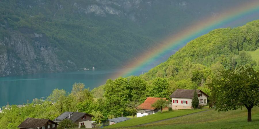 Die Ortsgemeinde Quarten im Kanton St. Gallen mit Blick auf einen Regenbogen über dem Walensee.