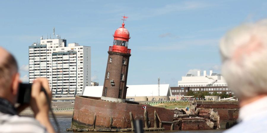 Schaulustige beobachten den abgesackten Moleturm in Bremerhaven.