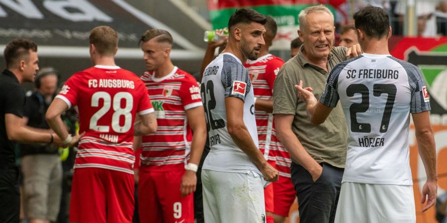 Freiburgs Trainer Christian Streich (2.v.r.) unterhält sich mit zwei seiner Spieler.