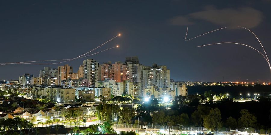 Israels Iron-Dome-Raketenabwehrsystem (r) feuert, um Raketen abzufangen, die aus dem Gazastreifen (l) auf Israel abgefeuert werden, kurz bevor eine Waffenruhe zwischen Palästinensern und Israel in Kraft tritt. Foto: Tsafrir Abayov/AP/dpa