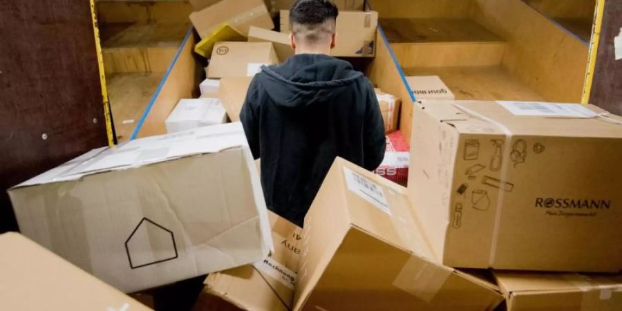 Pakete liegen in einem Paketzentrum von Deutsche Post und DHL. Die Deutschen bestellen gerne im Internet - und schicken viele Sachen wieder zurück. Foto: Julian Stratenschulte