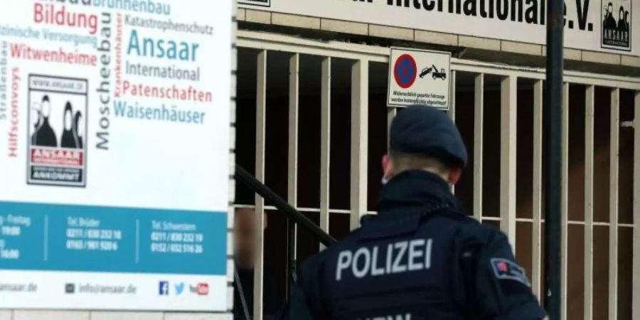 Polizeibeamte stehen vor dem Hauptsitz des Vereins Ansaar International in Düsseldorf. Foto: Martin Gerten