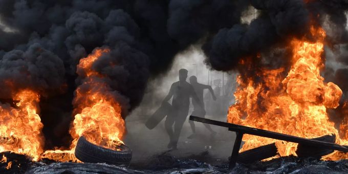 Ein Demonstrant wirft einen Autoreifen während eines Protests im Norden der libanesischen Hauptstadt Beirut ins Feuer. proteste beirut