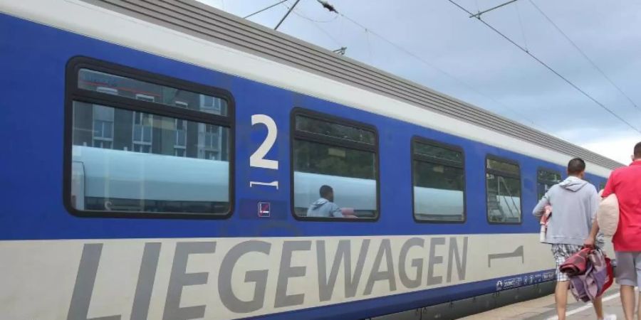 Reisende gehen zu einem Nachtzug (EuroNight) der ÖBB (Österreichische Bundesbahnen), der zur Abfahrt nach Wien im Bahnhof Altona bereit steht. Foto: Bodo Marks/dpa