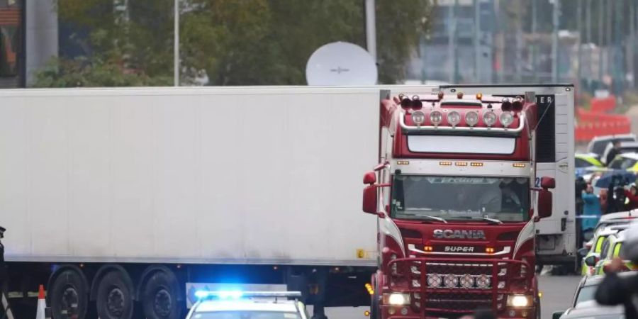 Ein Polizeiauto eskortiert den Lkw, in dem 39 Leichen gefunden worden waren, beim Verlassen des Waterglade Industrieparks. Foto: Aaron Chown/PA Wire/dpa