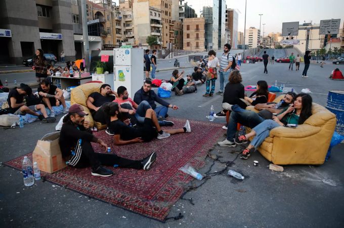 Demonstranten haben eine grosse Strasse besetzt, und sitzen auf der Fahrbahn auf mitgebrachtem Sofa und auf Teppichen. Proteste im Libanon