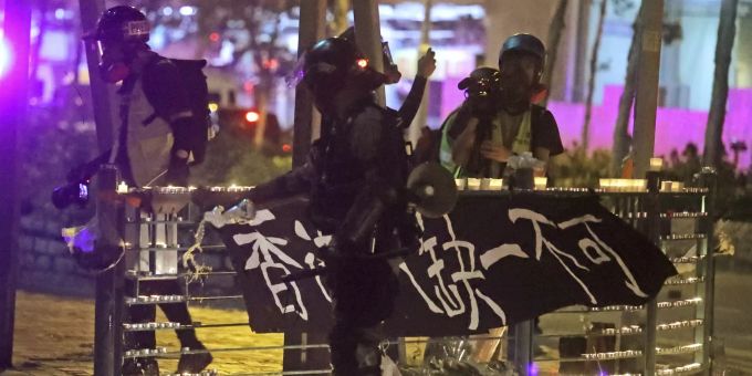 Ein Polizist löscht die von Demonstranten platzierten Kerzen aus. Hong Kong Protests