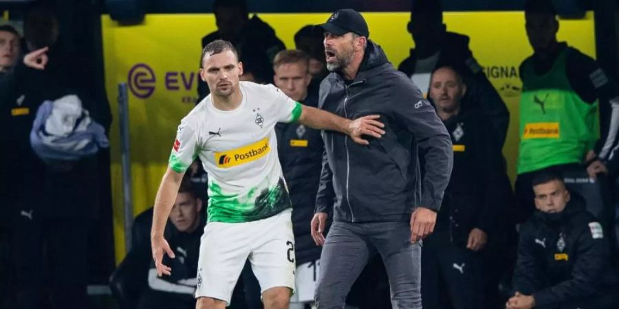 Die Gladbacher um Tony Jantschke (l) und Trainer Marco Rose sind trotz der Niederlage beim BVB weiter an der Bundesliga-Spitze. Foto: Guido Kirchner/dpa