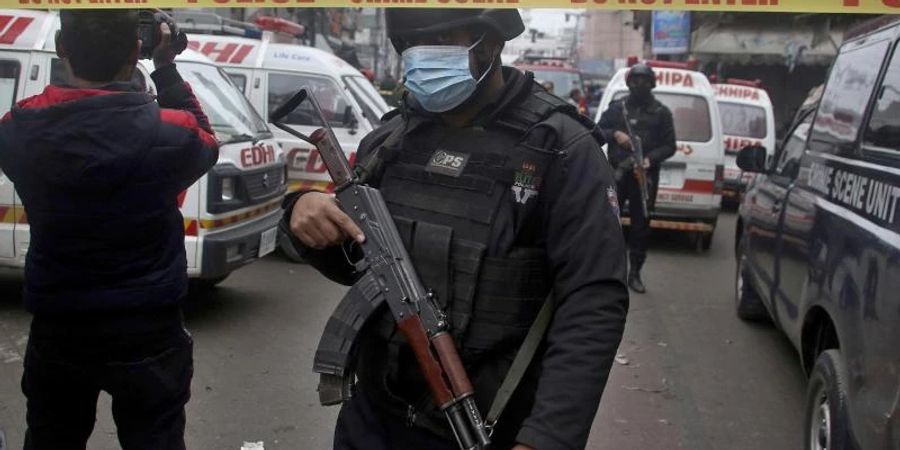 Polizisten stehen am Anschlagsort in Lahore, während Krankenwagen darauf warten Verletzte abzutransportieren. Foto: K.M. Chaudary/AP/dpa