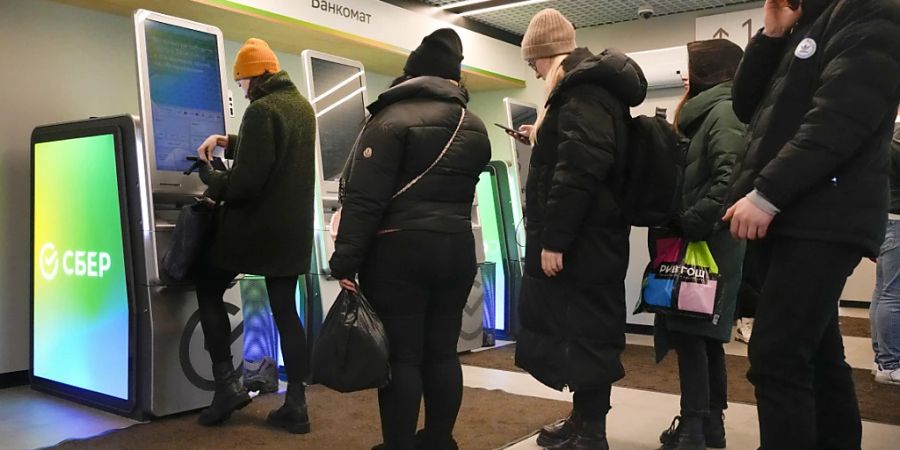 Menschen in St. Petersburg heben Geld von ihren Konten bei der von Sanktionen betroffenen Sberbank ab. Die Schweizer Tochtergesellschaft der russischen Grossbank meldet, bei ihr gehe die Arbeit weiter.