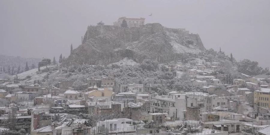 Blick bei Schneefall auf den Parthenon-Tempel. Wegen starker Schneefälle sind in Griechenland an mehreren Orten Flüge ausgefallen. Foto: Thanassis Stavrakis/AP/dpa