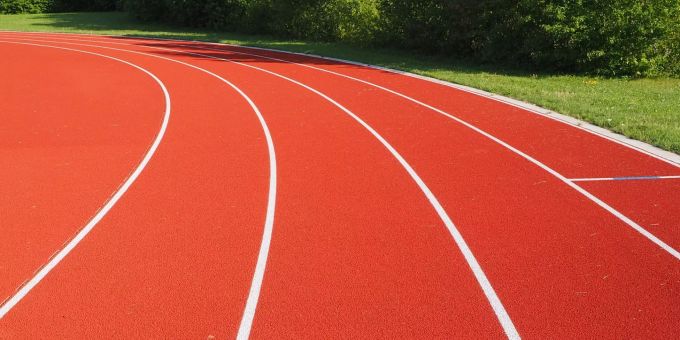 Eine Tartanbahn auf einer Sportanlage im Sommer.